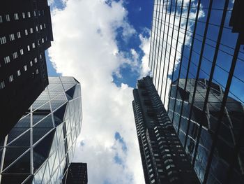 Low angle view of modern building against cloudy sky