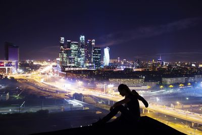 Man and illuminated buildings against sky in city at night