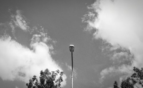 Low angle view of floodlight against cloudy sky