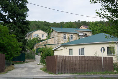 Street amidst houses and buildings against sky