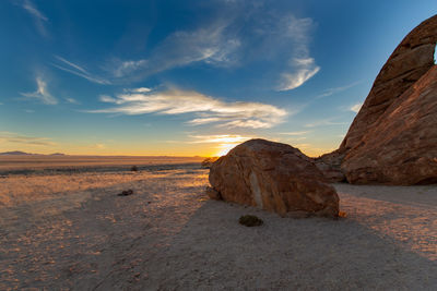 Rock formation on land against sky during sunset