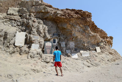 Rear view of man standing against rock formation