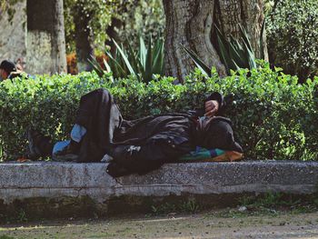 Woman with dog against trees
