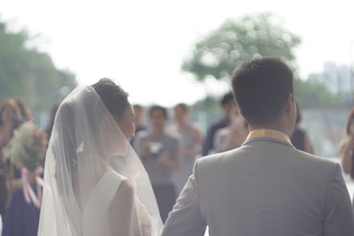 Rear view of couple kissing against blurred background