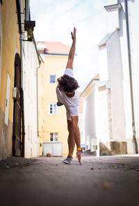 Young man exercising by building