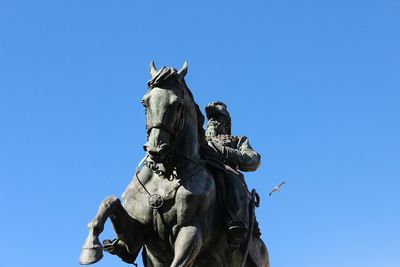 Low angle view of statue against clear blue sky