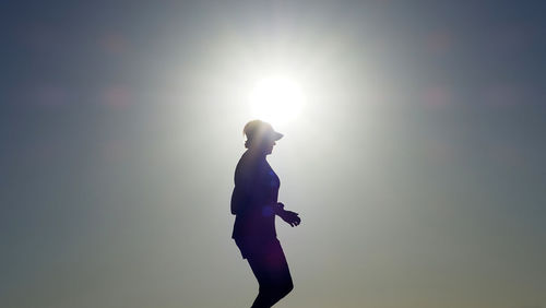 Side view of silhouette man standing against sky during sunset