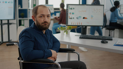 Portrait of young man sitting in office