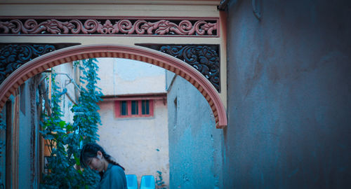 Woman standing by door of building