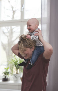 Mother carrying baby on shoulders