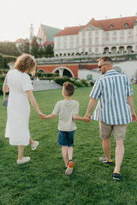 Rear view of family standing on grassy field