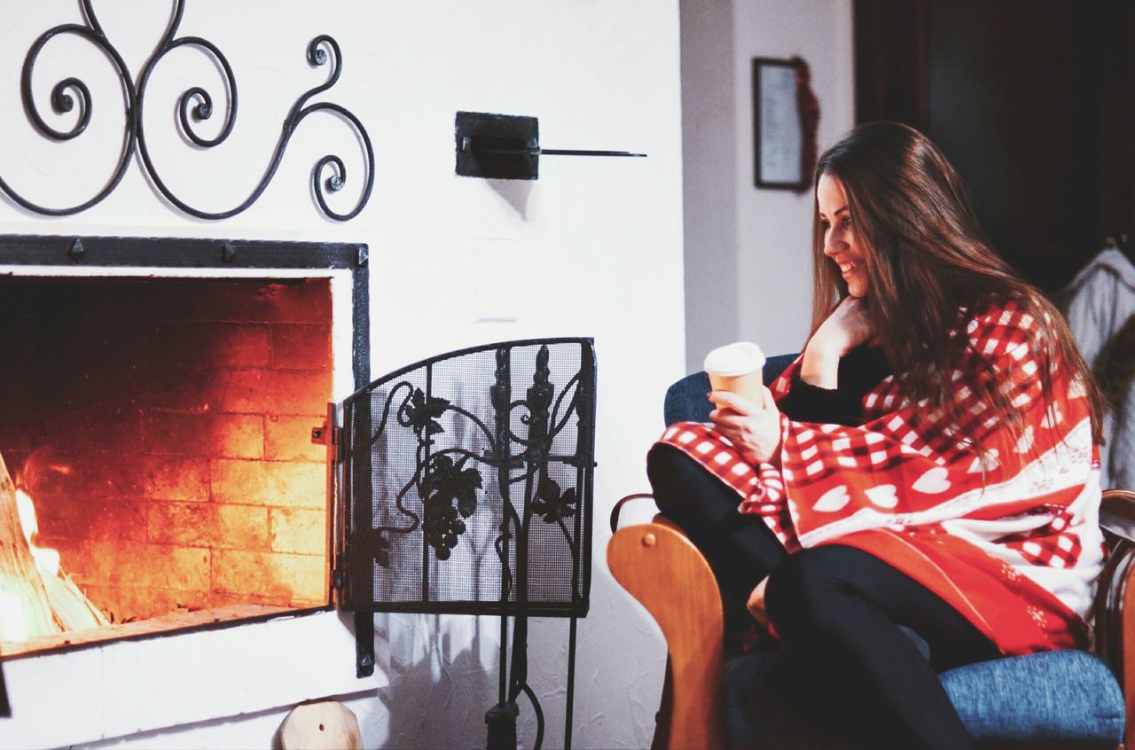 YOUNG WOMAN SITTING IN FRONT OF HOUSE