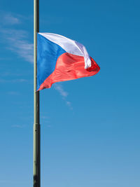 Low angle view of flag against blue sky