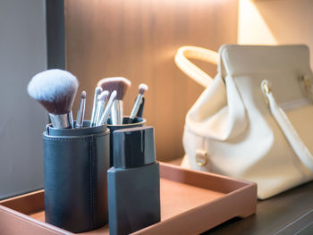 Close-up of make-up brushes in container on table at home