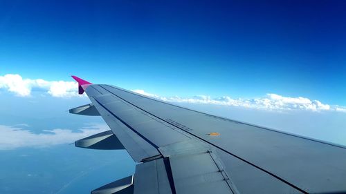 Cropped image of airplane flying in blue sky