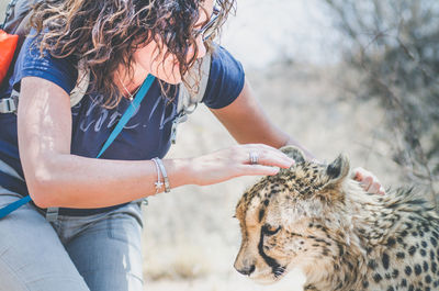 Close-up of woman with leopard outdoors