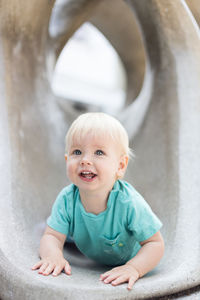 Child playing on outdoor playground. toddler plays on school or kindergarten yard. active kid on