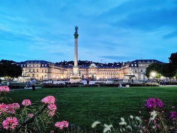 View of flowering plants in city against cloudy sky