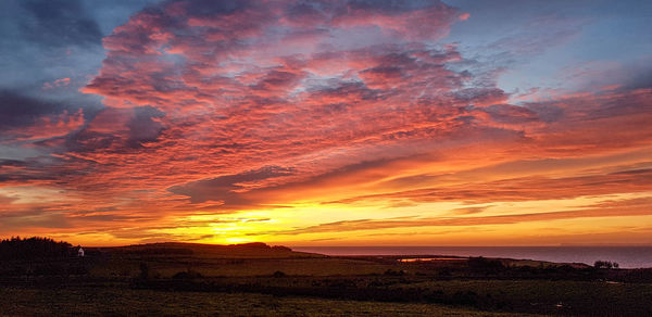 Scenic view of dramatic sky over sea during sunset