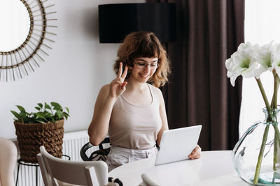 Full length of woman using mobile phone while standing on table