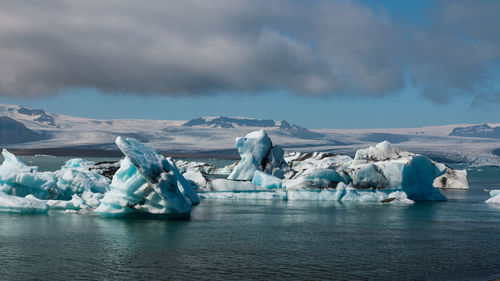 Panoramic view of frozen lake against cloudy sky