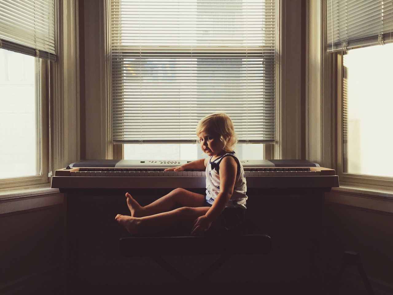 indoors, sitting, window, young adult, lifestyles, home interior, leisure activity, relaxation, casual clothing, full length, young women, person, side view, chair, waist up, glass - material, looking through window, contemplation