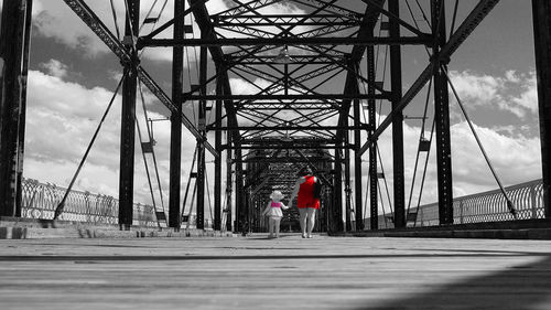 Rear view of man on bridge against sky