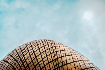 Low angle view of modern building against cloudy sky