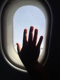 Close-up of hand touching window