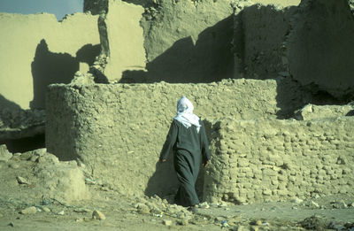 Rear view of woman standing on rock
