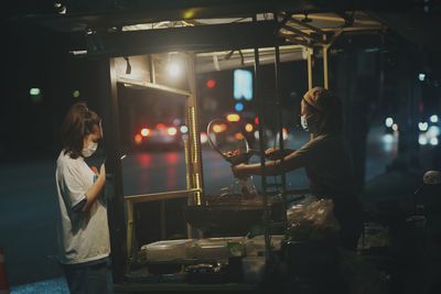 People standing in illuminated market at night