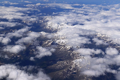 Alps from the air - snowy peaks under the clouds