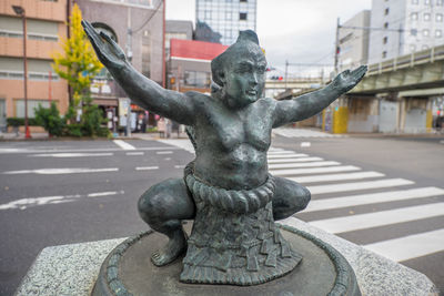 Close-up of statue against city