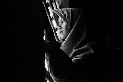 Low angle view of girl looking through window at home