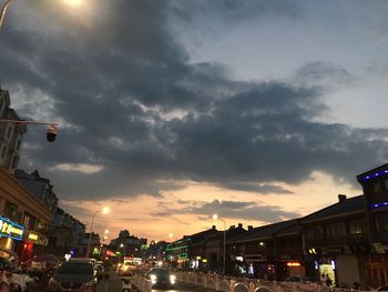 City street against cloudy sky at dusk