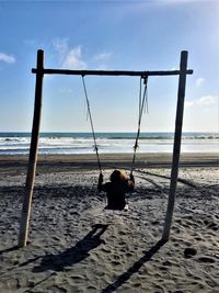 Rear view of person on beach against sky