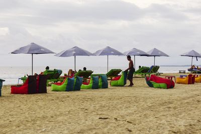 Chairs on beach against sky