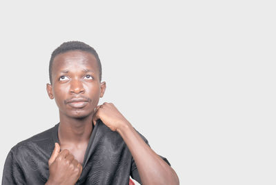 Portrait of young man standing against white background