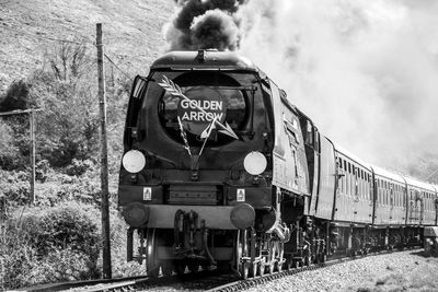 Train on railroad track against mountain