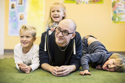 Portrait of playful children with teacher in kindergarten