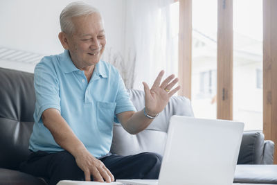 Man using mobile phone while sitting on sofa