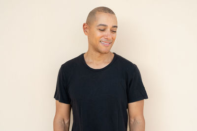 Portrait of young man standing against white background