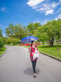 Woman carrying toddler daughter at park