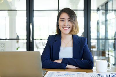 Portrait of a smiling young woman using phone