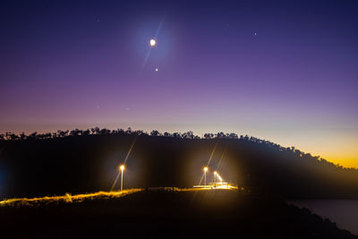 Illuminated lights against clear sky at night