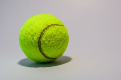 Close-up of tennis ball on gray background