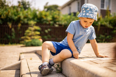 Full length of a boy sitting on wood