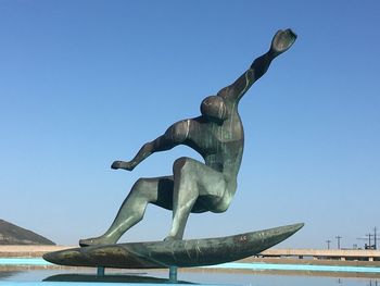 Low angle view of statue against clear blue sky