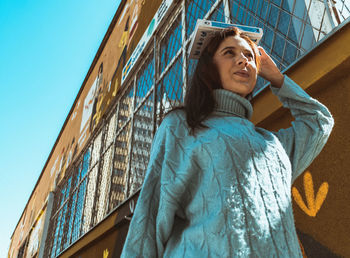 Low angle view of woman looking away against sky