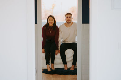 Portrait of happy friends standing against door